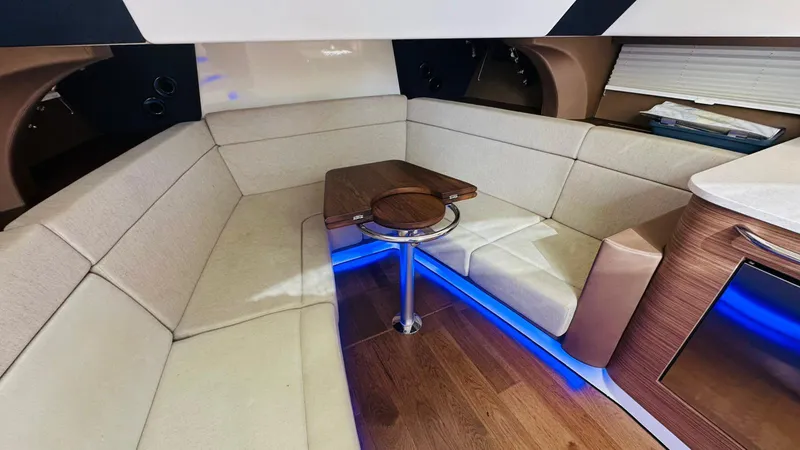 Slide: The Image of Interior of 2017 Boston Whaler 420 Outrage with beige seating and wooden table. - 18
