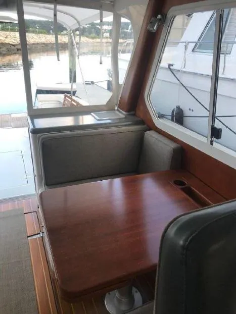 Slide: The Image of 2005 True North 38 Heritage boat interior with wooden table and cushioned seating. - 18