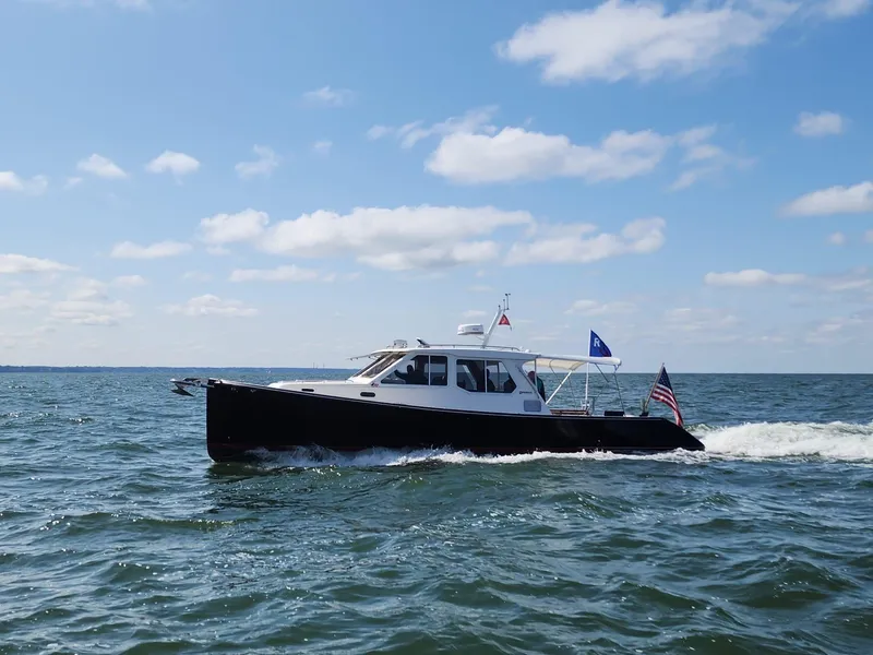 Slide: The Image of 2005 True North 38 Heritage boat cruising on open water under a clear sky. - 2