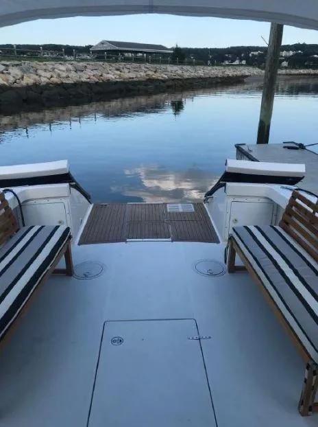 Slide: The Image of 2005 True North 38 Heritage boat with striped seating, docked by calm waters. - 21