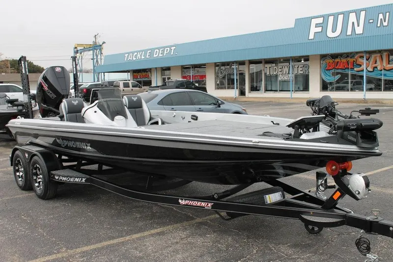 Slide: The Image of 2025 Phoenix 921 Elite II boat on trailer outside a tackle shop. - 2