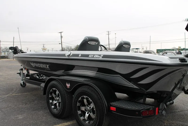 Slide: The Image of 2025 Phoenix 921 Elite II boat, sleek design, dual axle trailer, parked outdoors. - 6