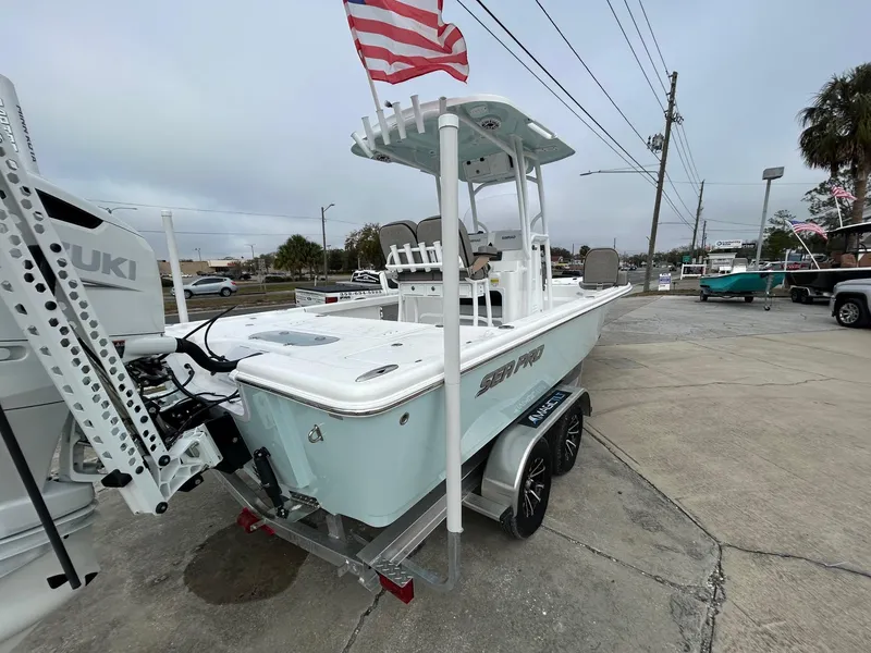 Slide: The Image of 2025 Sea Pro 250 Bay boat on trailer, American flag, outdoor dealership setting. - 3