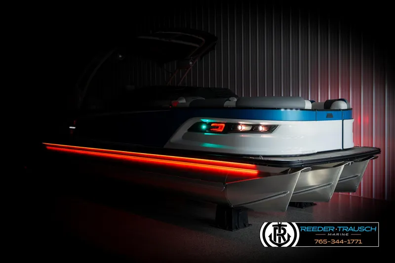 Slide: The Image of 2025 Avalon Excalibur LTD QLW boat with LED lights in a dimly lit showroom. - 4