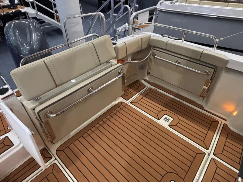 Slide: The Image of 2025 Ranger Tugs R-23 boat interior with foldable seating and teak flooring. - 13