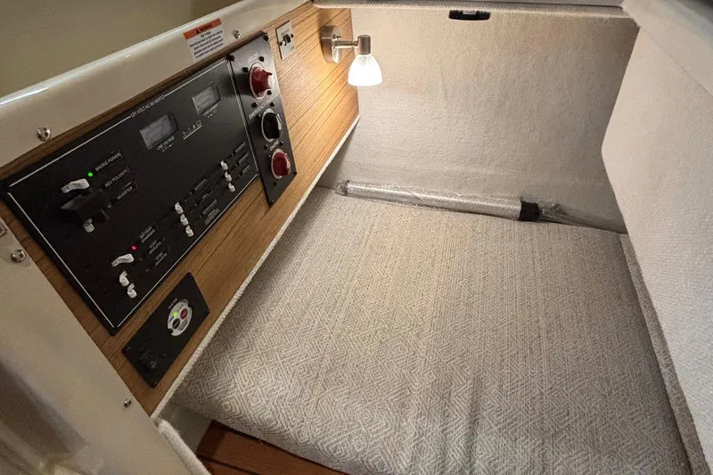 Slide: The Image of 2025 Ranger Tugs R-23 cabin interior with control panel and cozy sleeping area. - 15