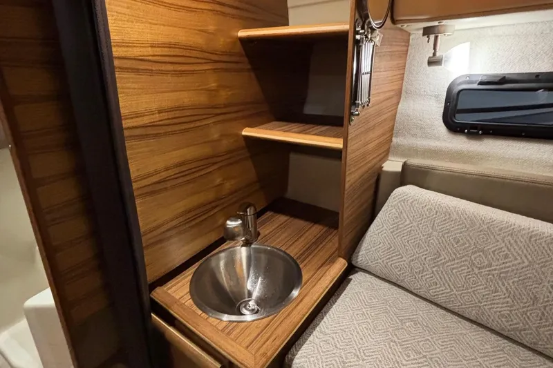 Slide: The Image of Interior of 2025 Ranger Tugs R-23, featuring a compact sink and cozy seating area. - 17