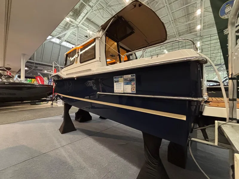Slide: The Image of 2025 Ranger Tugs R-23 boat displayed indoors at a boat show. - 2
