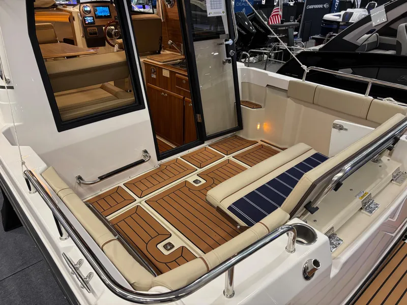 Slide: The Image of 2025 Ranger Tugs R-23 boat interior with teak flooring and cushioned seating. - 8