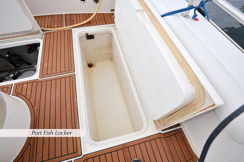 Slide: The Image of Open port fish locker on 1996 Mediterranean convertible boat with teak flooring. - 10