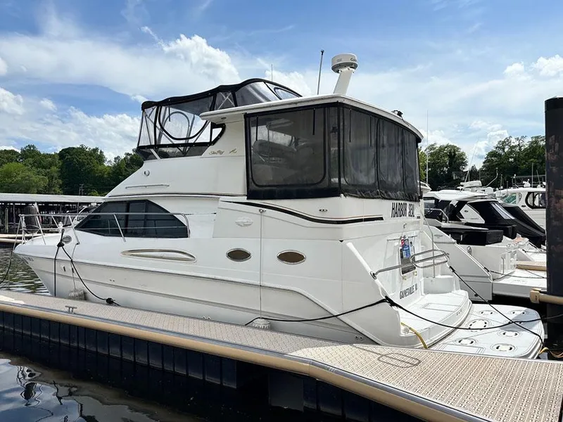 The Image of 1997 Sea Ray 370 Aft Cabin yacht docked at marina under blue sky. - 0