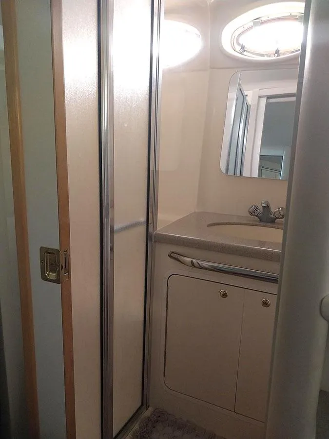 Slide: The Image of 1997 Sea Ray 370 Aft Cabin bathroom with shower, sink, and mirror. - 13