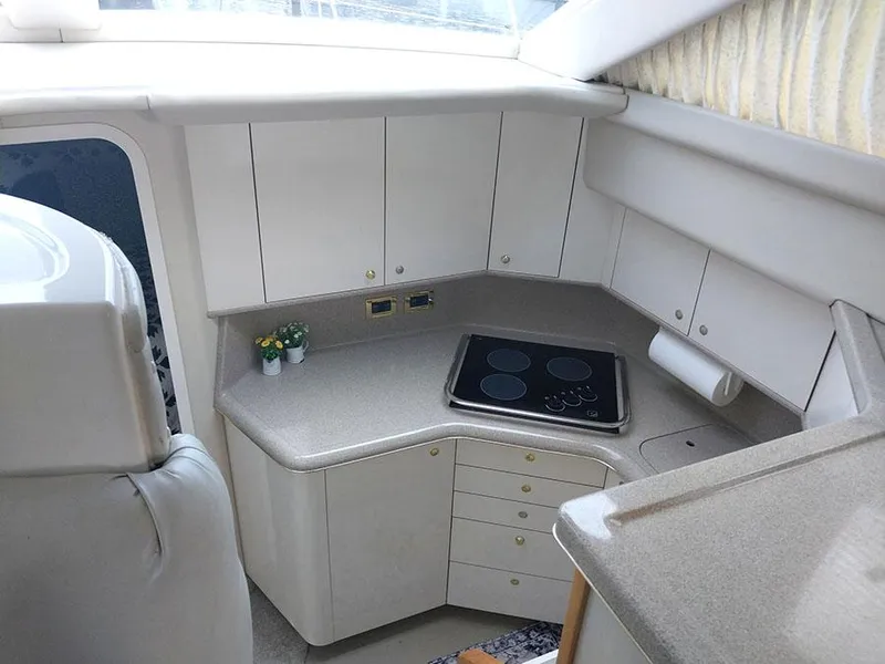 Slide: The Image of 1997 Sea Ray 370 Aft Cabin kitchen with stove, cabinets, and countertop. - 15