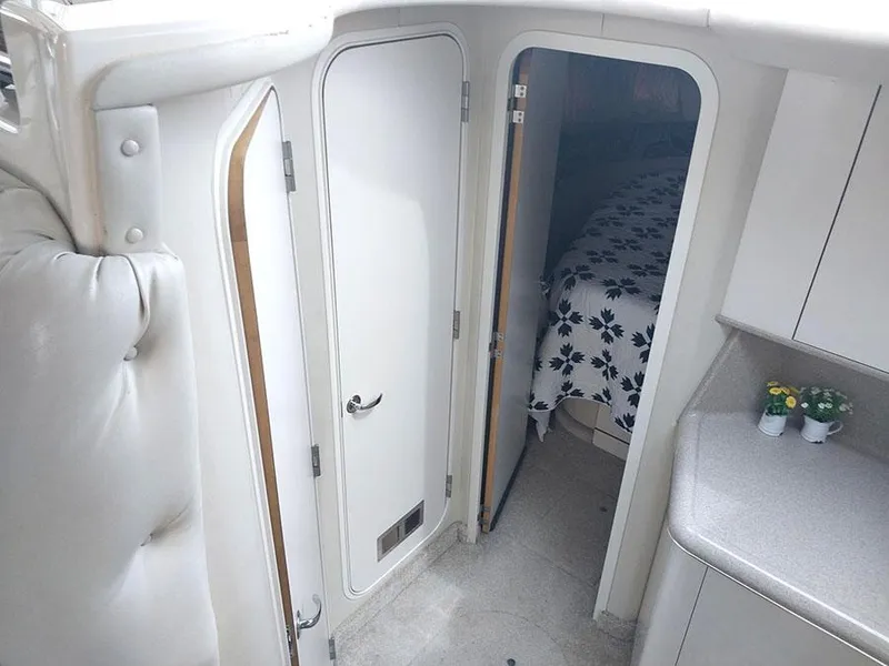 Slide: The Image of 1997 Sea Ray 370 Aft Cabin interior with door, floral bedding, and countertop. - 16