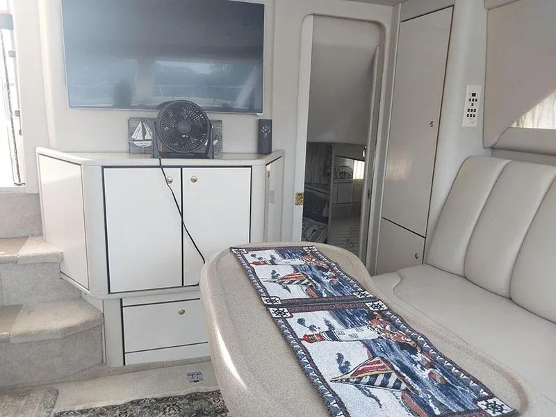 Slide: The Image of Interior of 1997 Sea Ray 370 Aft Cabin with seating, TV, and nautical decor. - 17