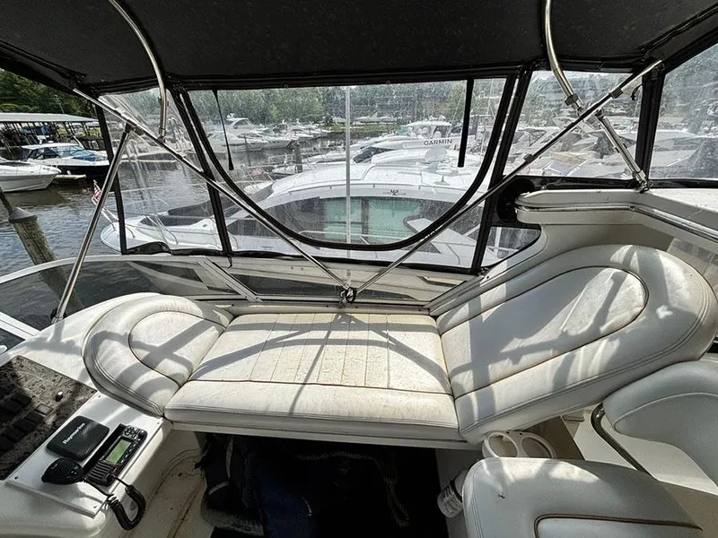 Slide: The Image of 1997 Sea Ray 370 Aft Cabin interior with white seating and marina view. - 25