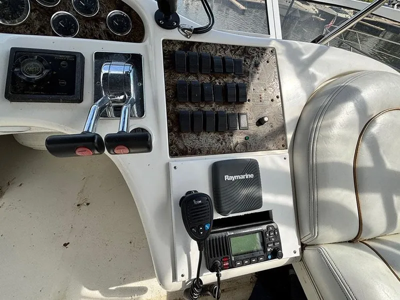 Slide: The Image of 1997 Sea Ray 370 Aft Cabin helm with controls, switches, and Raymarine equipment. - 26