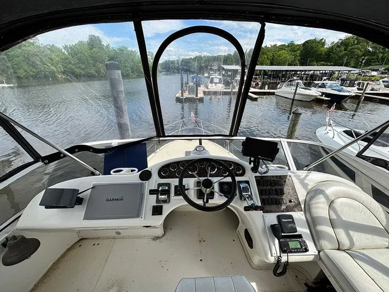Slide: The Image of 1997 Sea Ray 370 Aft Cabin helm with river view and marina backdrop. - 27