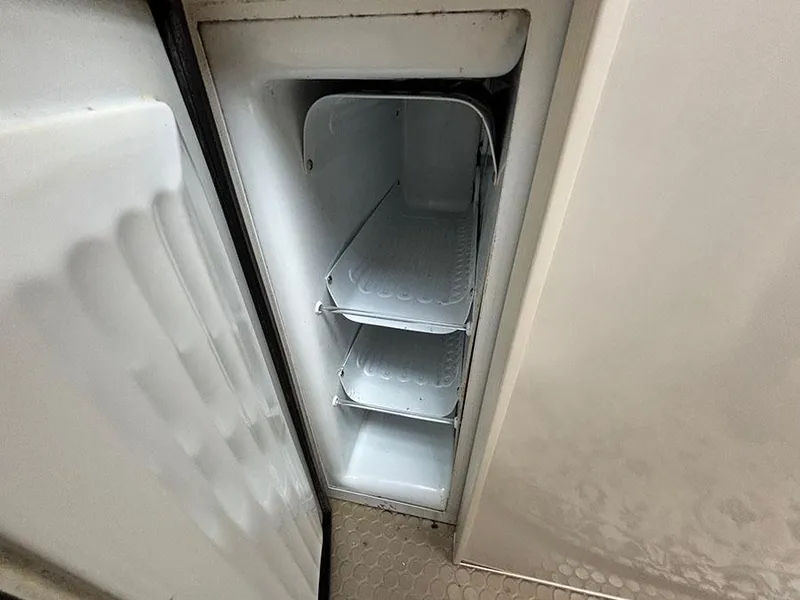 Slide: The Image of Open refrigerator in 1997 Sea Ray 370 Aft Cabin boat, showing empty shelves. - 38