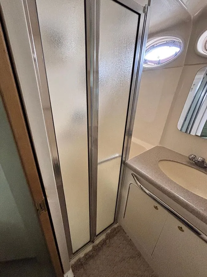 Slide: The Image of 1997 Sea Ray 370 Aft Cabin bathroom with shower, sink, and oval window. - 43