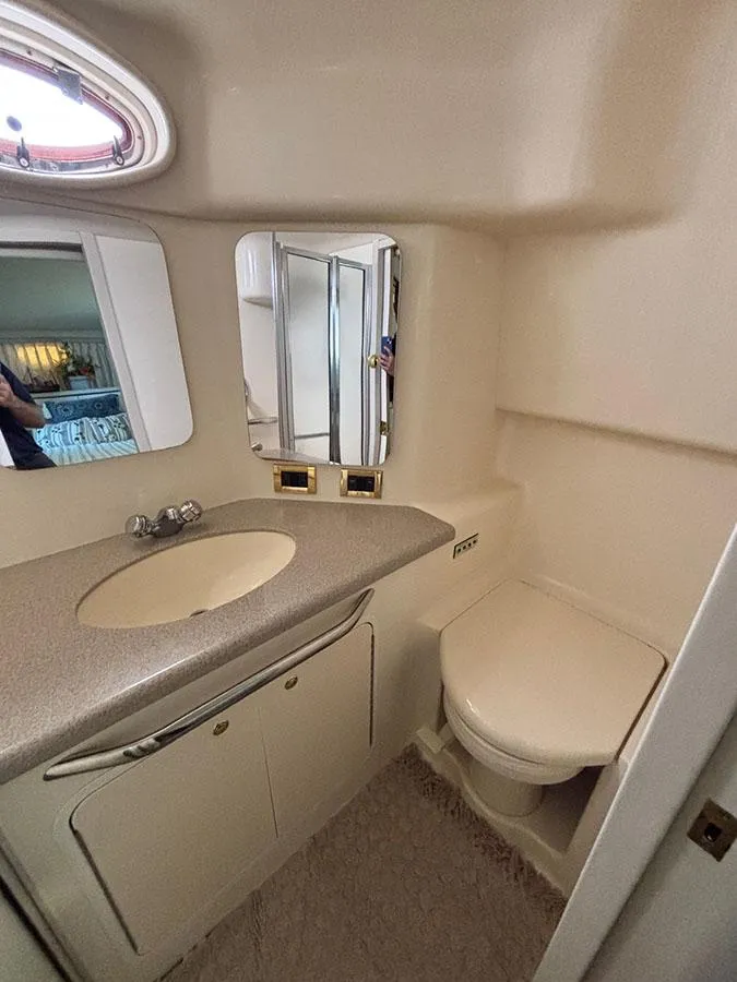 Slide: The Image of 1997 Sea Ray 370 Aft Cabin bathroom with sink, mirror, and toilet. - 44