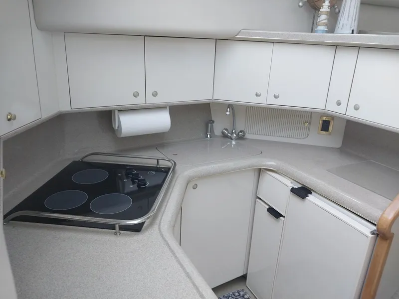 Slide: The Image of 1997 Sea Ray 370 Aft Cabin kitchen with stove, sink, and cabinets. - 5