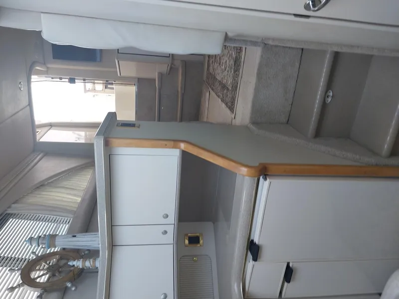 Slide: The Image of Interior of a 1997 Sea Ray 370 Aft Cabin yacht, featuring a compact kitchen area. - 6