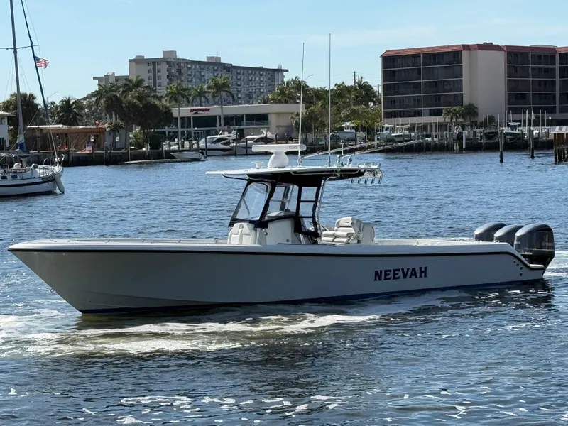 The Image of 2018 Bluewater Center Console boat on water, cityscape background, named "NEEVAH". - 0
