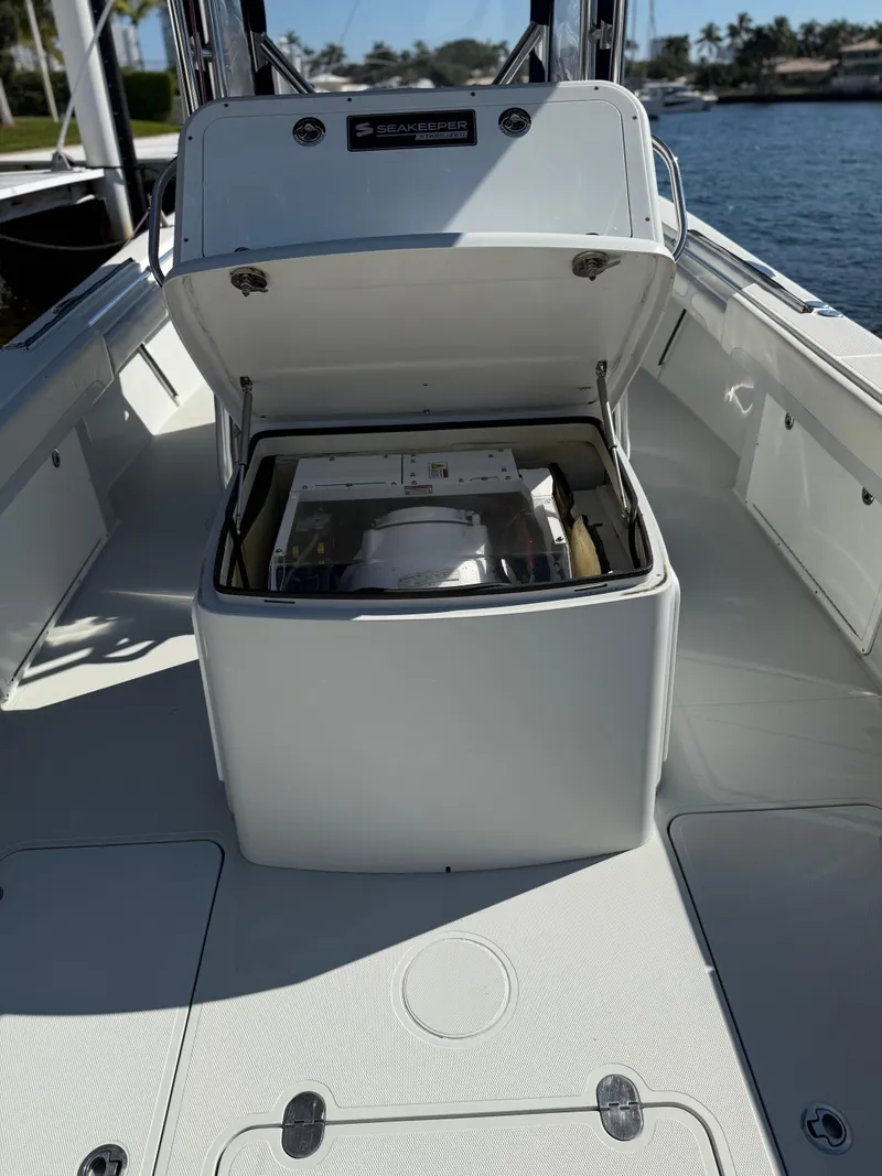 Slide: The Image of 2018 Bluewater Center Console boat with open storage compartment, docked by the water. - 16