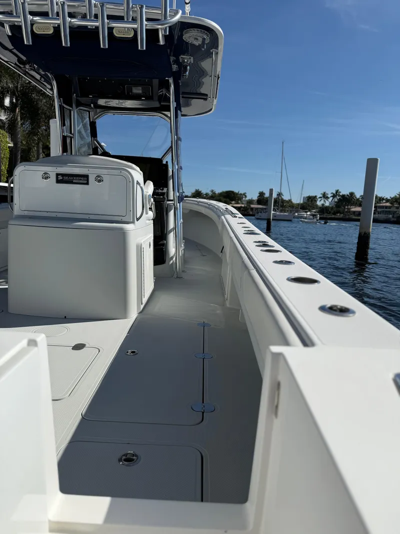 Slide: The Image of 2018 Bluewater Center Console boat docked by the water on a sunny day. - 4