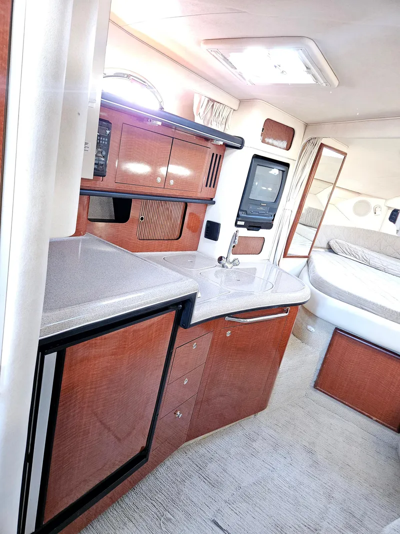 Slide: The Image of 2003 Sea Ray 340 Sundancer interior with kitchenette and sleeping area. - 2