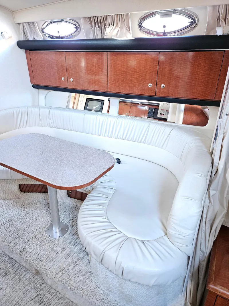 Slide: The Image of Interior of 2003 Sea Ray 340 Sundancer with white seating and wooden cabinets. - 8