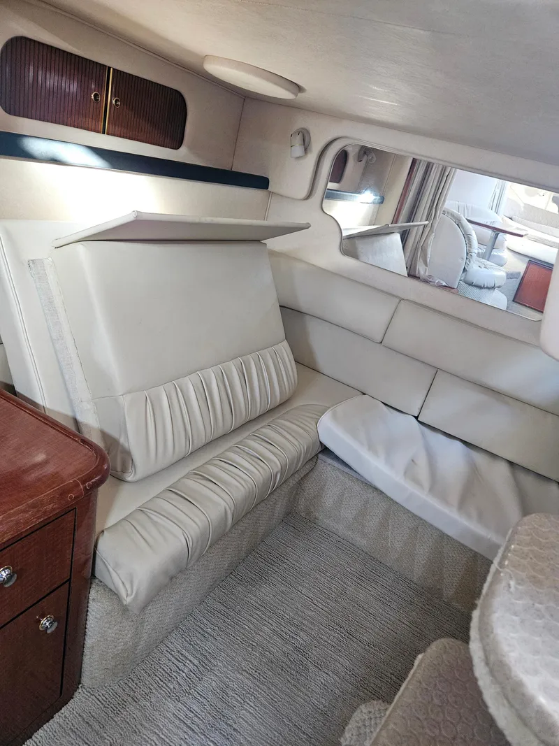 Slide: The Image of Interior of 2003 Sea Ray 340 Sundancer, featuring plush seating and elegant cabinetry. - 9