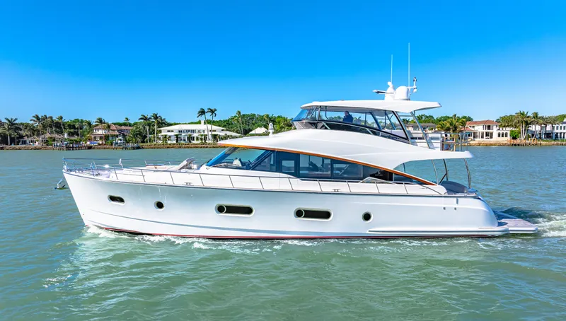 Slide: The Image of 2025 Belize 66 Daybridge yacht cruising on a sunny day, with waterfront homes in the background. - 18