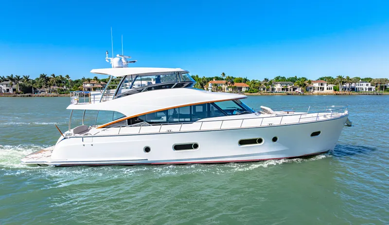 Slide: The Image of 2025 Belize 66 Daybridge yacht cruising on a sunny day, with waterfront homes in the background. - 20