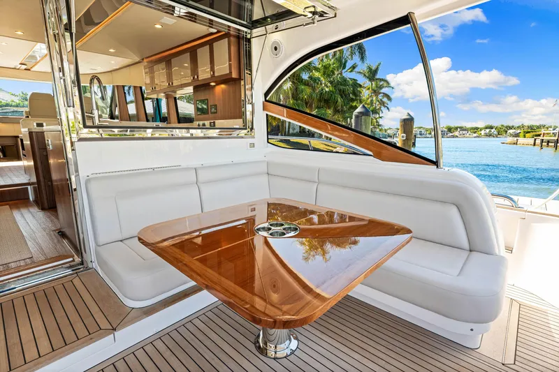 Slide: The Image of Luxurious seating area on 2025 Belize 66 Daybridge yacht with wooden table and scenic water view. - 35