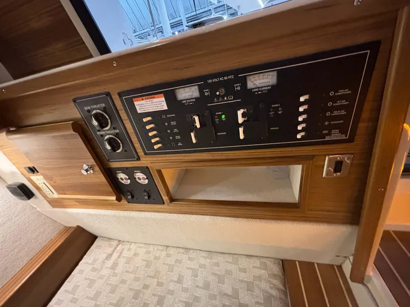 Slide: The Image of Control panel inside 2025 Ranger Tugs R-29 S boat, featuring switches and gauges. - 12