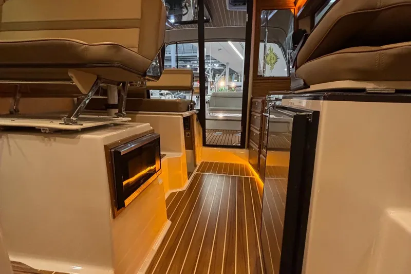 Slide: The Image of 2025 Ranger Tugs R-29 S interior with modern seating and ambient lighting. - 13