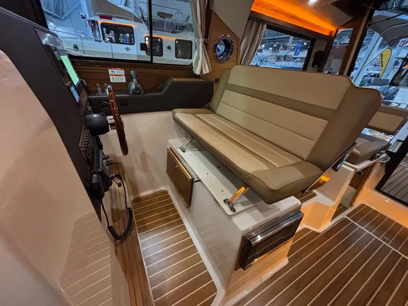 Slide: The Image of 2025 Ranger Tugs R-29 S interior with helm seat and wood flooring. - 18