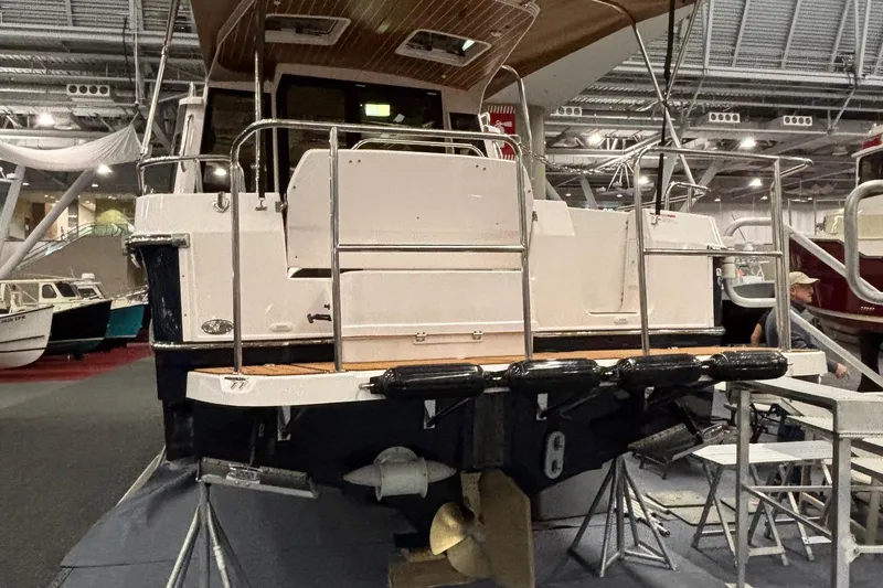 Slide: The Image of 2025 Ranger Tugs R-29 S boat displayed indoors, showcasing rear deck and propeller. - 2