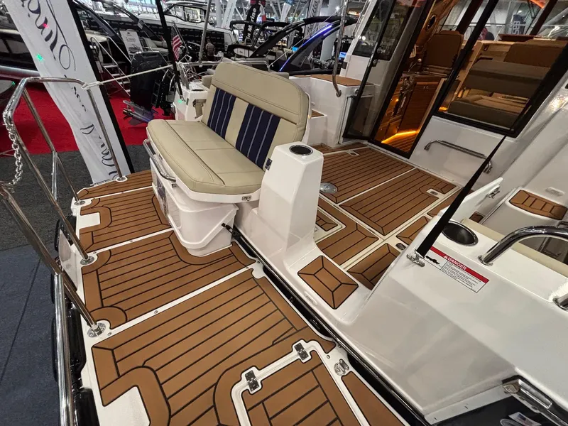 Slide: The Image of 2025 Ranger Tugs R-29 S boat interior with teak flooring and cushioned seating. - 6