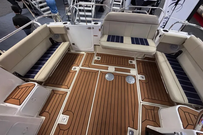 Slide: The Image of 2025 Ranger Tugs R-29 S boat interior with teak flooring and cushioned seating. - 7