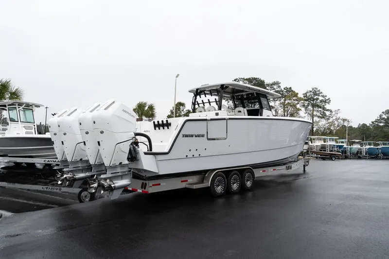 The Image of 2025 Twin Vee 400 GFX2 CC boat on trailer, featuring triple outboard engines. - 0