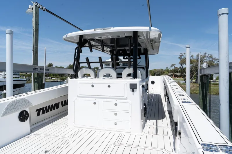 Slide: The Image of 2025 Twin Vee 400 GFX2 CC boat, white deck, center console, docked under clear sky. - 11