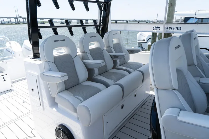 Slide: The Image of 2025 Twin Vee 400 GFX2 CC boat interior with luxurious seating and ocean backdrop. - 14