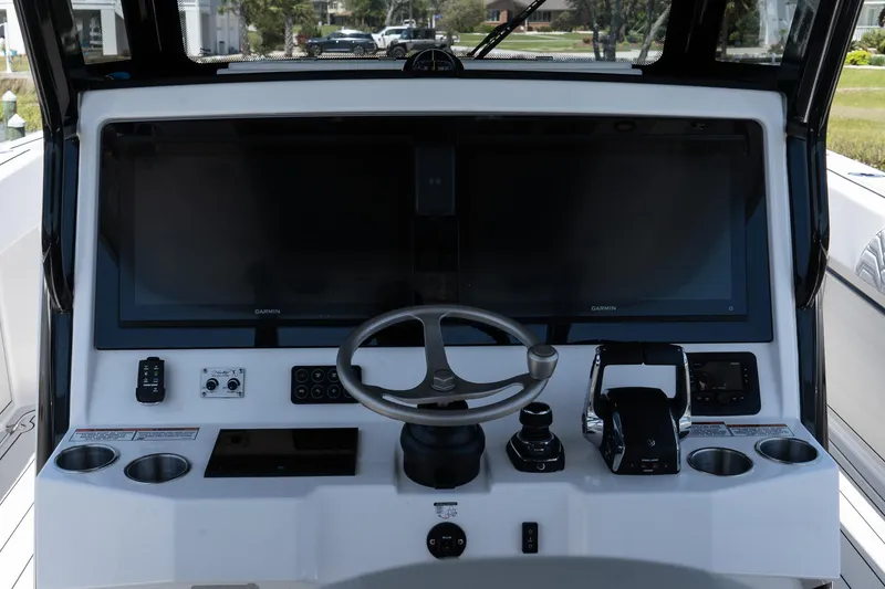 Slide: The Image of 2025 Twin Vee 400 GFX2 CC boat dashboard with steering wheel and controls. - 19