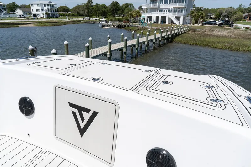 Slide: The Image of 2025 Twin Vee 400 GFX2 CC boat docked by waterfront homes and pier. - 24