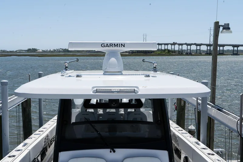 Slide: The Image of 2025 Twin Vee 400 GFX2 CC boat with Garmin radar on calm waters. - 25