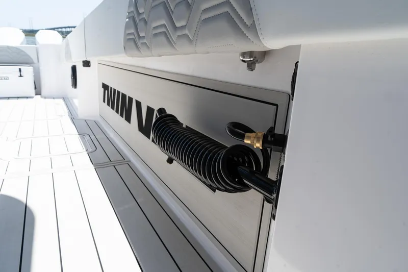 Slide: The Image of 2025 Twin Vee 400 GFX2 CC boat deck with coiled hose and branding. - 34