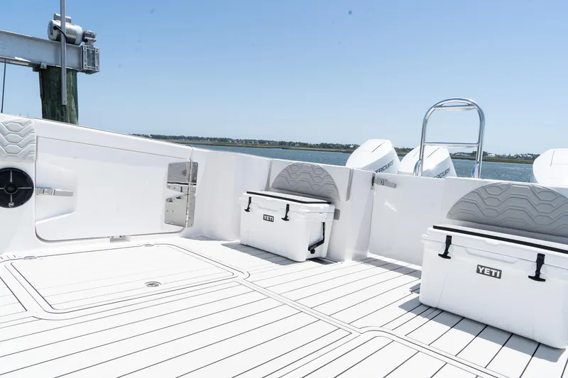 Slide: The Image of Twin Vee 400 GFX2 CC 2025 boat deck with Yeti coolers, white seating, and ocean view. - 41